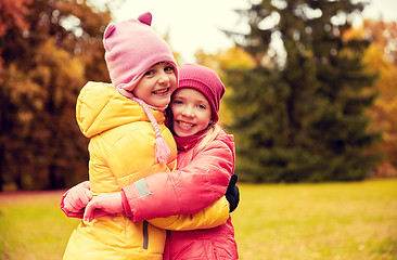 Image showing two happy little girls hugging in autumn park