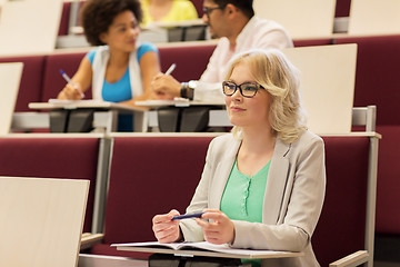 Image showing student girl writing to notebook in lecture hall