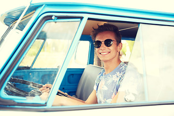 Image showing smiling young hippie man driving minivan car