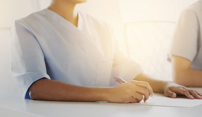 Image showing close up of doctor taking notes at hospital