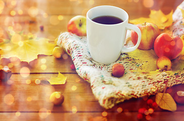 Image showing close up of tea cup on table with autumn leaves