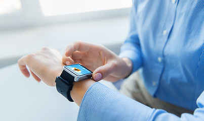 Image showing close up of hands with music player on smart watch