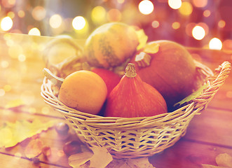 Image showing close up of pumpkins in basket on wooden table