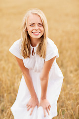 Image showing smiling young woman in white dress on cereal field