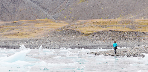 Image showing Woman walking over the beach at Jokulsarlon glacier lagoon - Ice