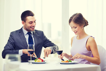 Image showing smiling couple eating main course at restaurant