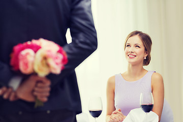 Image showing young woman looking at man with flower bouquet