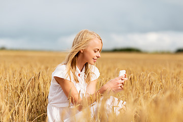 Image showing happy woman with smartphone and earphones