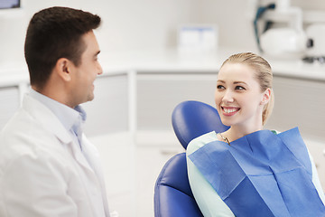 Image showing happy male dentist with woman patient at clinic