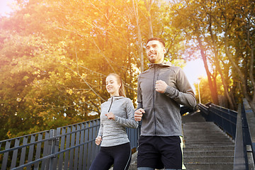 Image showing happy couple running downstairs in city