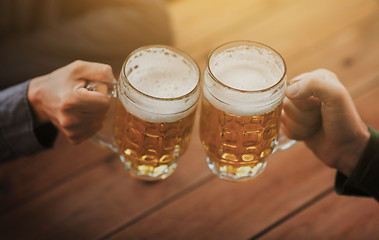 Image showing close up of hands with beer mugs at bar or pub