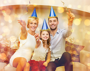 Image showing smiling family in blue hats with cake