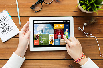 Image showing close up of woman with tablet pc on wooden table