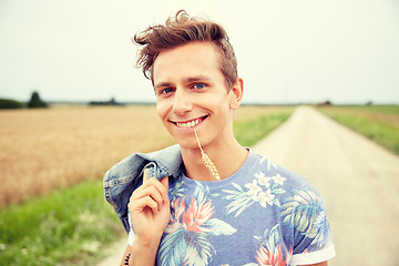 Image showing smiling young hippie man on country road