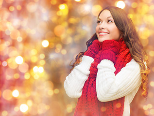 Image showing happy woman in scarf and mittens over lights