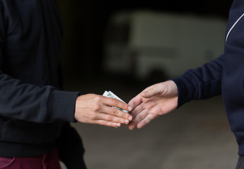 Image showing close up of addict paying money to drug dealer