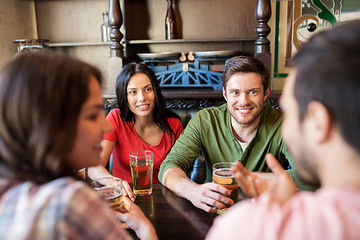 Image showing happy friends drinking beer at bar or pub