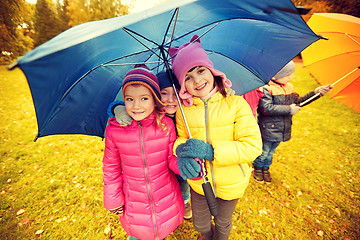 Image showing happy children with umbrella in autumn park