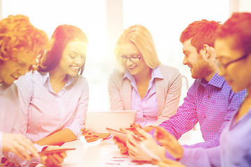 Image showing smiling team with table pc and papers working