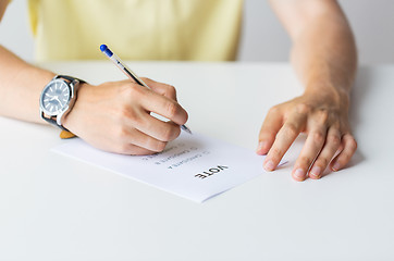 Image showing close up of hands with vote or ballot on election