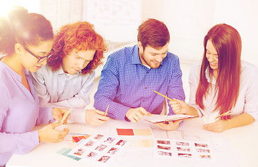 Image showing team with color samples and blueprint at office