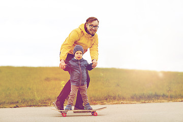 Image showing happy father and little son on skateboard