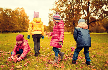 Image showing group of children collecting leaves in autumn park