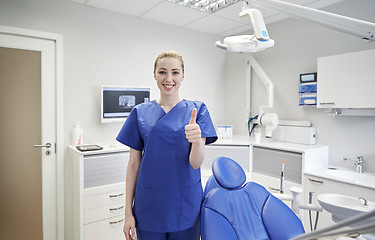 Image showing happy female dentist showing thumbs up at clinic