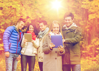 Image showing group of smiling friends with tablets in park
