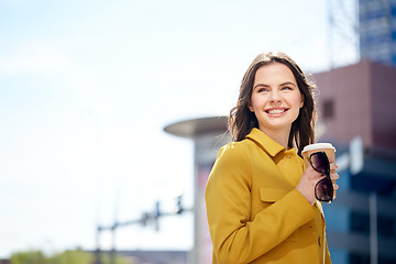 Image showing happy young woman drinking coffee on city street