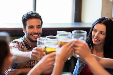 Image showing happy friends drinking beer at bar or pub