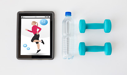 Image showing close up of tablet pc, dumbbells and water bottle