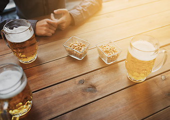 Image showing close up of hands with beer mugs at bar or pub