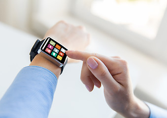 Image showing close up of hands setting smart watch with icons