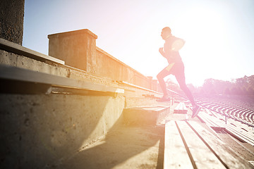 Image showing happy young man running upstairs on stadium