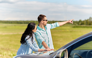 Image showing man and woman with car pointing finger outdoors