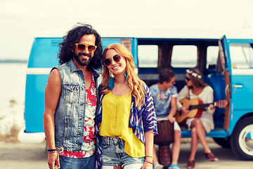 Image showing smiling hippie couple with friends over minivan