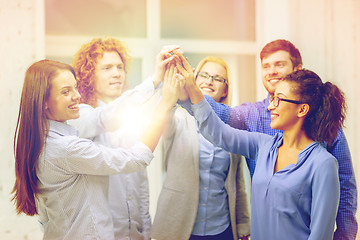 Image showing creative team doing high five gesture in office