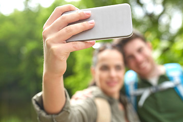 Image showing couple with backpacks taking selfie by smartphone