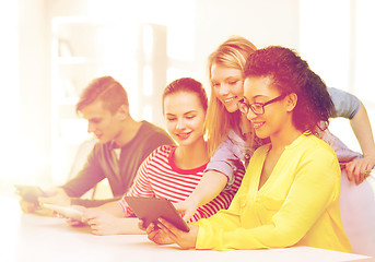 Image showing smiling students looking at tablet pc at school