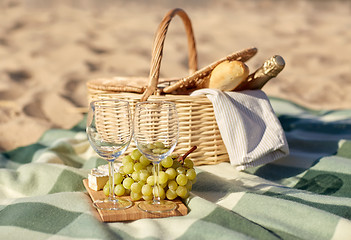 Image showing picnic basket with wine glasses and food on beach