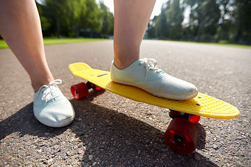 Image showing close up of female feet riding short skateboard