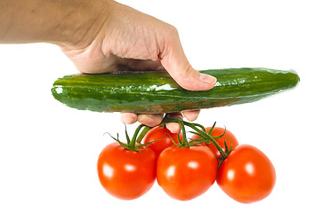 Image showing Person holding a cucumber and a bunch of tomatoes