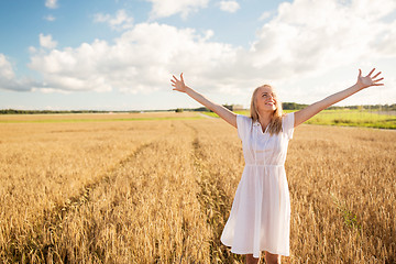 Image showing smiling young woman in white dress on cereal field