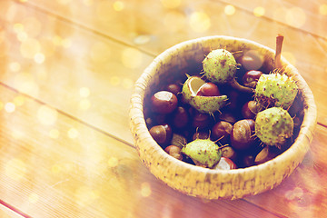 Image showing close up of chestnuts in basket on wooden table