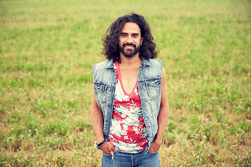 Image showing smiling young hippie man on green field