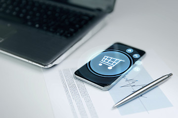 Image showing close up of smartphone with shopping cart icon