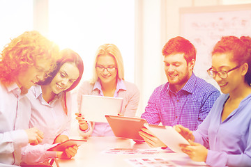 Image showing smiling team with table pc and papers working