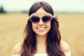 Image showing smiling young hippie woman in sunglasses outdoors