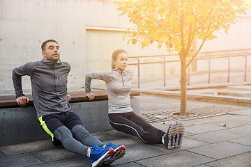 Image showing couple doing triceps dip on city street bench